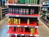 many cans of soda on the shelves in the store