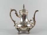 an antique silver teapot with a handle on a stand