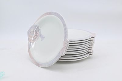several white plates stacked on top of each other on a white surface