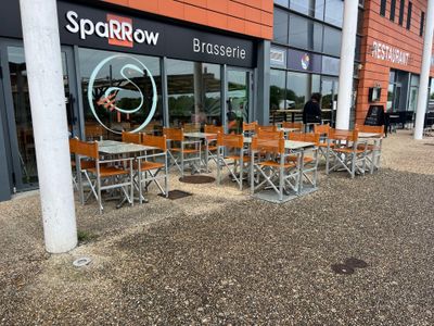 de nombreuses tables et chaises devant un magasin