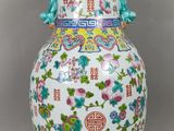 un vase blanc orné de motifs colorés sur un fond gris