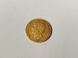 a close up of a gold coin on a white surface