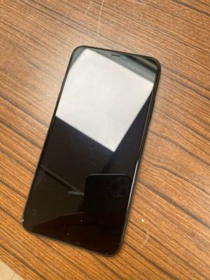 un téléphone portable noir posé sur une table en bois