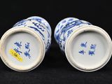 pair of blue and white vases on a black background