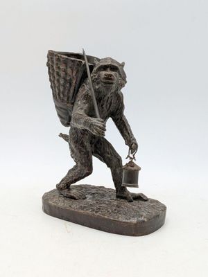 statue représentant un homme portant un panier et un seau sur le dos