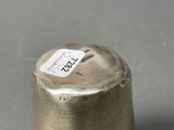 a small metal object on a table with a tag on it