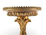 an image of a gold plate on a stand on a white background
