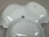 a white bowl with a hole in the middle of it