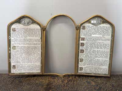 une paire de pages de livre encadrées de laiton ancien, posées sur une table en bois