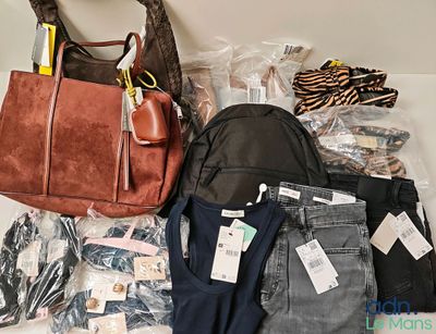 a lot of clothes and a purse on the floor
