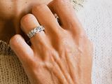 someone is wearing a white sweater and a diamond ring on their neck