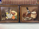two framed paintings of a bird and a basket of eggs on a table