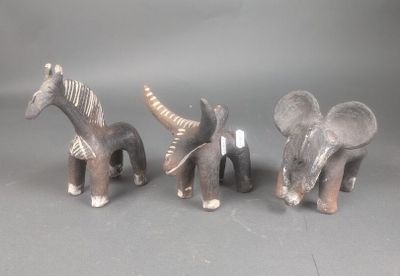 trois figurines d'éléphants et une girafe sur fond gris