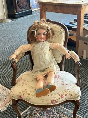 a doll that is sitting on a chair in a room
