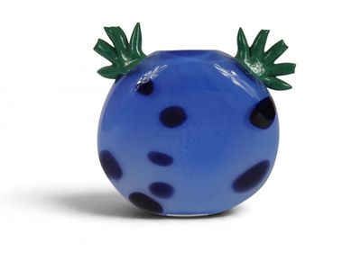 un vase bleu orné de taches noires et de feuilles vertes