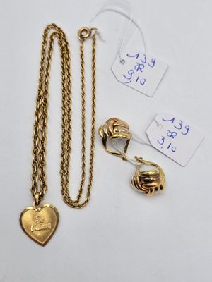 un gros plan sur un collier en or orné d'un pendentif en forme de cœur et d'autres éléments