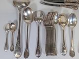 a lot of silver spoons and spoon knives on the table