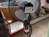 a fan that is sitting on a stand in a room