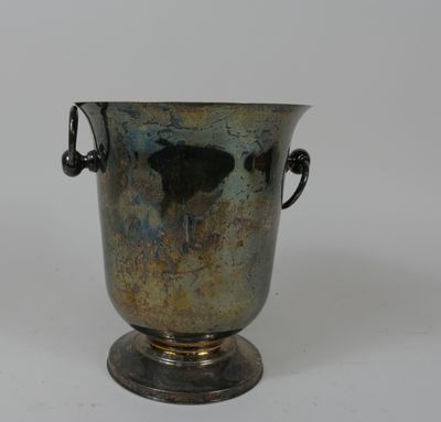 a silver vase that is sitting on a white surface