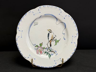 une assiette sur laquelle est peint un oiseau, posée sur une table