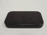 the back of a black cell phone sitting on top of a white table