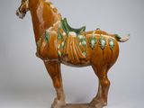 statue of a brown horse with a green and white blanket on it ' s back