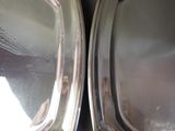 two silver trays sitting on top of each other