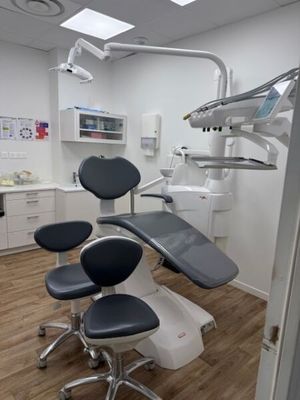 an image of a dentist ' s office with a chair and dental equipment
