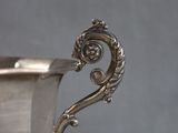 a silver cup sitting on top of a saucer