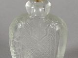 a clear glass bottle with a gold lid