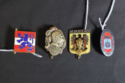 quatre badges différents sont suspendus à une ficelle sur une surface noire