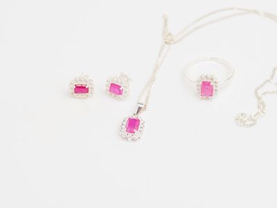 parure de bijoux en argent plaqué, sertie de pierres roses sur fond blanc