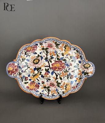 un gros plan d'une assiette décorée de fleurs et de feuilles