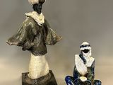 deux figurines représentant une femme et un homme assis par terre