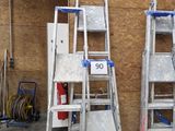 Plusieurs échelles sont alignées contre un mur dans un garage