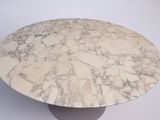 a white marble table with a black base on a white background