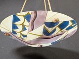 a bowl hanging from a gold chain on a table