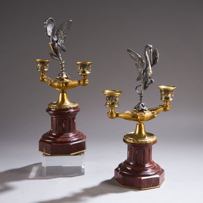 une paire de bougeoirs en argent et en or surmontés d'oiseaux