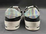 pair of black and white sneakers with hologized soles on a gray surface