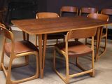 a wooden table with chairs around it in a room