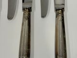 four knives and a knife holder on a table