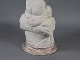 a statue of a woman sitting on top of a rock