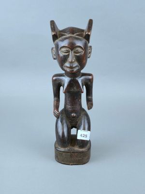une image représentant une statue en bois d'un chat portant une étiquette sur la poitrine
