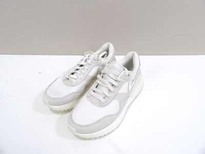 des baskets posées sur une table blanche, avec un mur blanc en arrière-plan