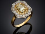 a yellow and white diamond ring on a black surface