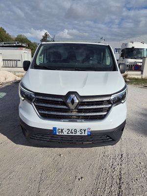 l'avant d'une camionnette blanche garée sur un chemin de terre
