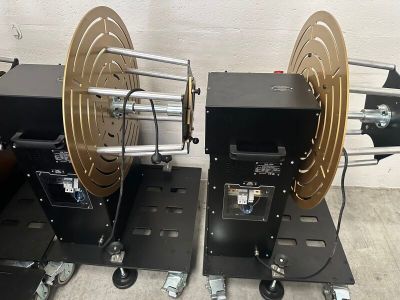 two reels are sitting on top of wheels in a room