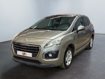 La voiture argentée est garée dans une grande pièce au sol noir.