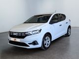 La voiture blanche est garée dans une grande pièce aux murs blancs.
