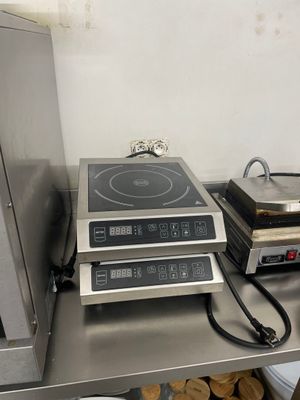 une cuisinière et une plaque de cuisson posées sur une étagère dans une cuisine